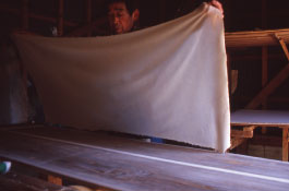 幸次郎は、濡れた紙を刷毛で手際よく板に貼っていく。