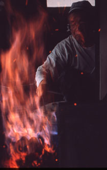 刀匠は、炎の大きさや、炭の中で赤められた玉鋼の赤み具合を見て、こまめに送風の強さや玉鋼を置く位置を微調整していく。